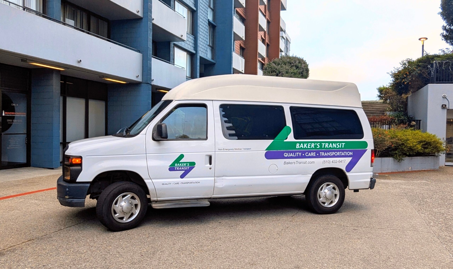 Certified caregiver drivers assisting a wheelchair passenger into a Baker's Transit accessible van